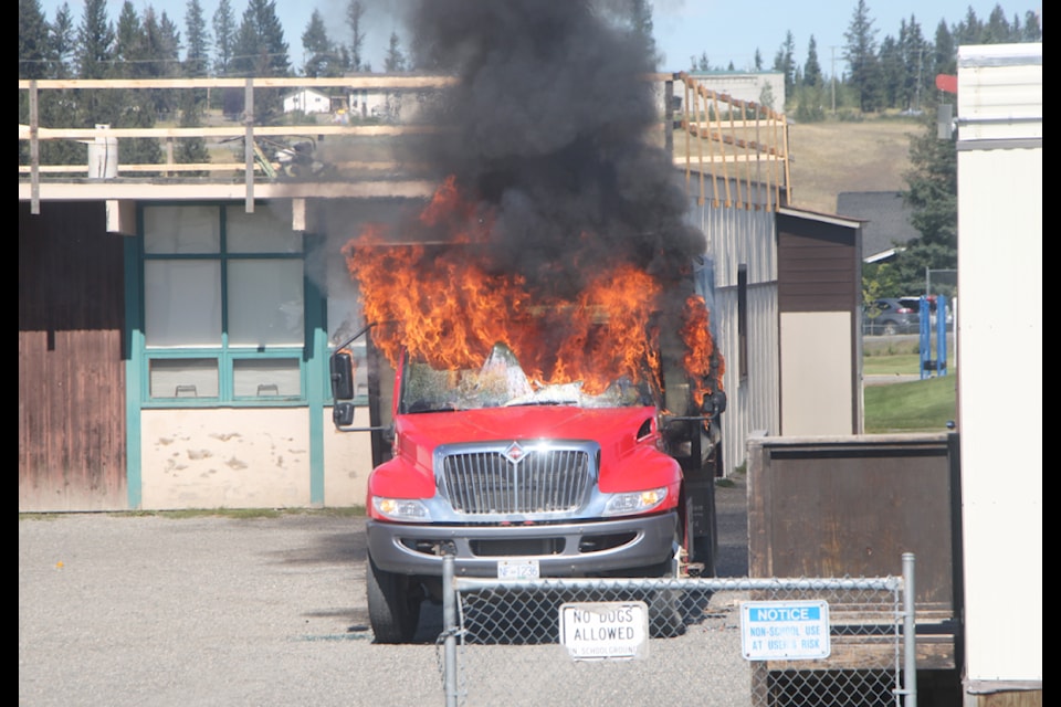 100 Mile Fire Rescue works to extinguish a truck fire by 100 Mile Elementary School on Monday, Aug. 19. (Patrick Davies photo - 100 Mile Free Press)