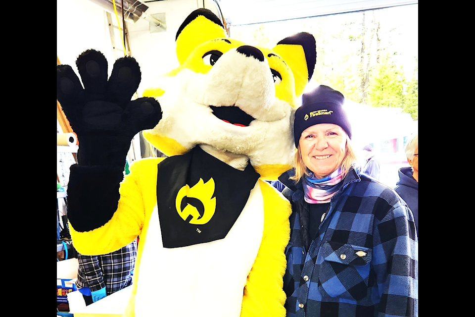 South Green Lake resident Kathy Traynor was pleased to get her photo taken with the FireSmart mascot Ember at the 2024 Open House. (Ken Alexander photo)