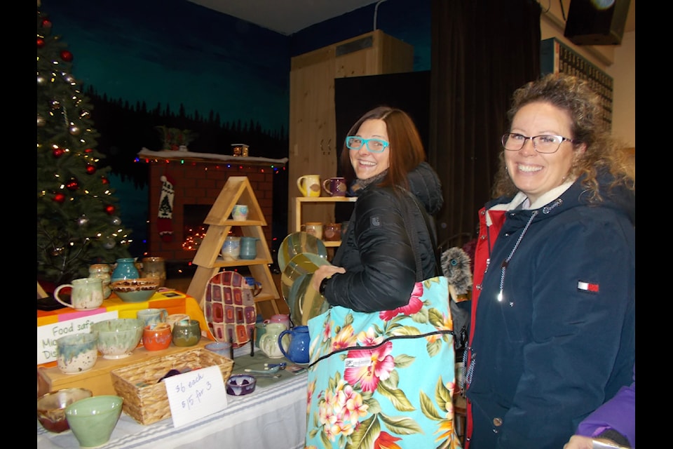 Michelle Stajcer and Shay Kort enjoy Joanne Bandstra's Hand Thrown pottery at the Interlakes Community Centre’s Nov. 9 Christmas Fair. (Diana Forster photo)