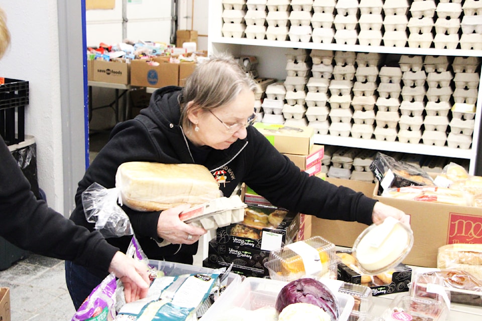 A 100 Mile House Food Bank Society volunteer packs a Christmas Hamper last week. (Patrick Davies photo - 100 Mile Free Press)