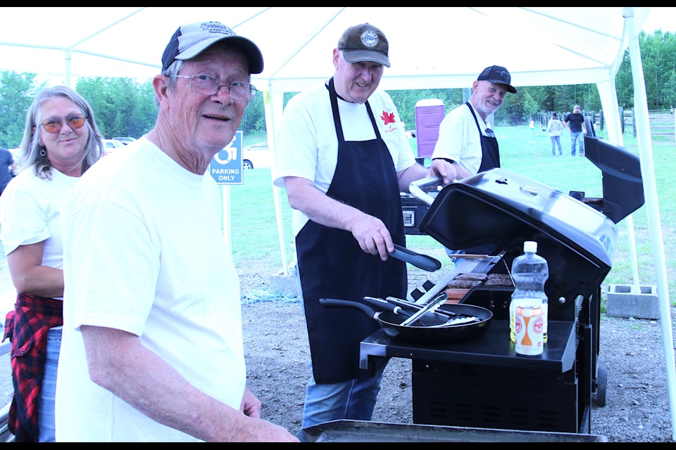 Sue Olliffe (left), Dave Hilliard, John Vybiral and Grant McDanaldi locked after the barbecuing of hamburgers at the 70 Mile Canada Day event. (Ken Alexander photo)