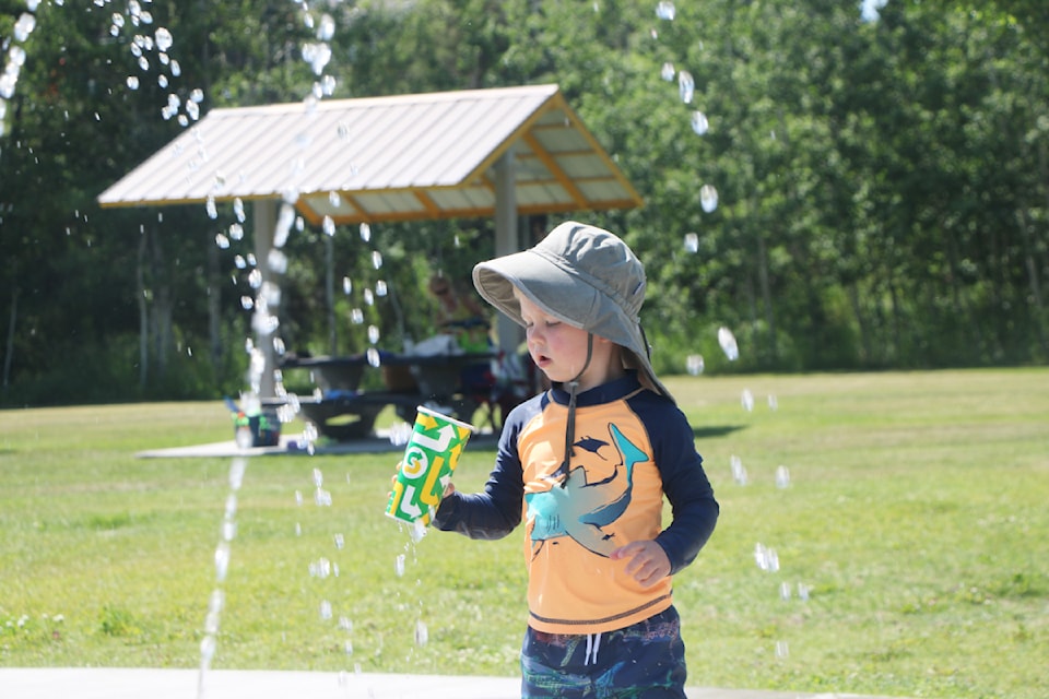 Quesnel's Henry Huggins beat the heat on Monday, July 8 by playing in Centennial Park's Spray Park. (Patrick Davies photo - 100 Mile Free Press)