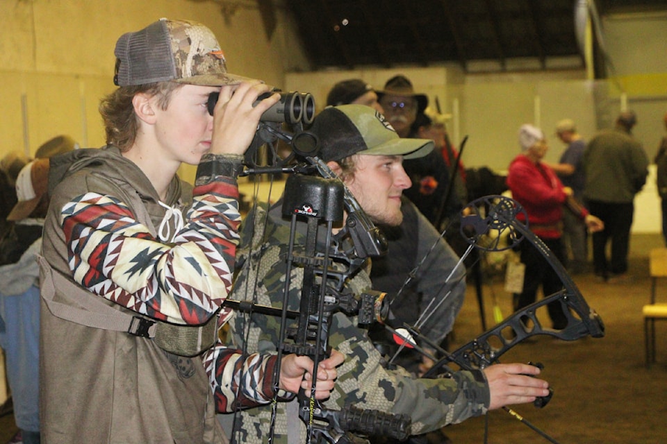 Reichert Sanford and Mason Pincott plan out their next shots while taking part in the Big Horn Archery Club's annual Indoor 3D Shoot at the Stan Halcro Agriplex. (Patrick Davies photo - 100 Mile Free Press)