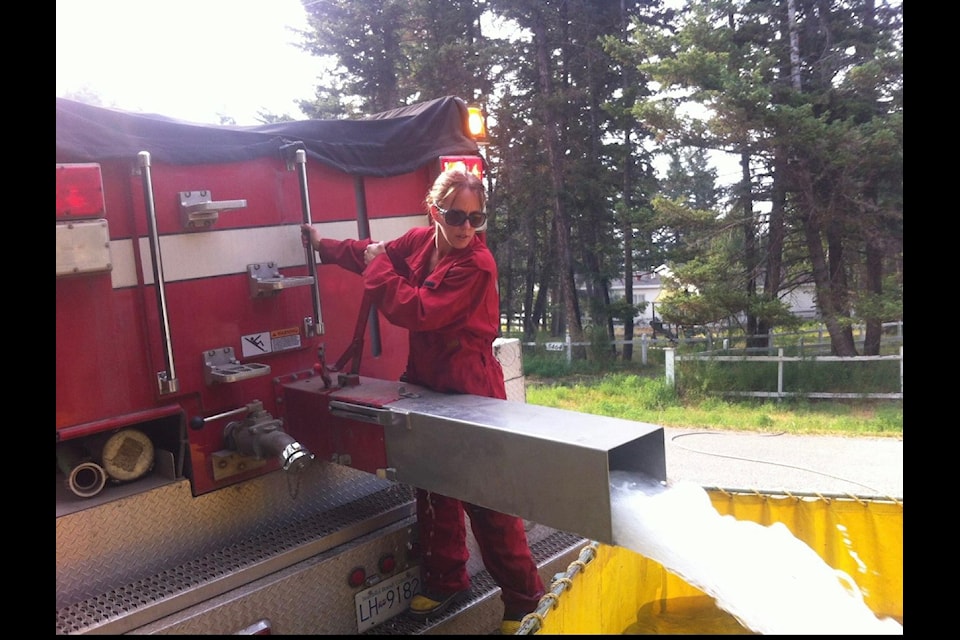 Julie Machado, the new fire chief of the Lac La Hache volunteer fire department, fills a bladder during a fire. (Photo submitted - Julie Machado)