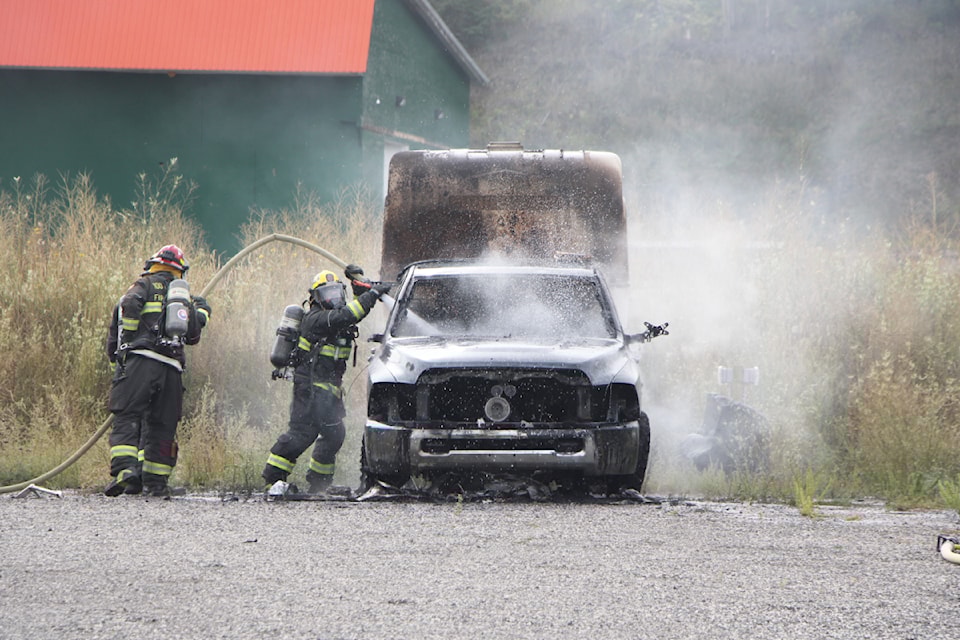Members of 100 Mile Fire Rescue work to extinguish a truck that caught fire near Peter Skene Ogden Secondary School on Tuesday, Sept. 17. (Patrick Davies photo - 100 Mile Free Press)