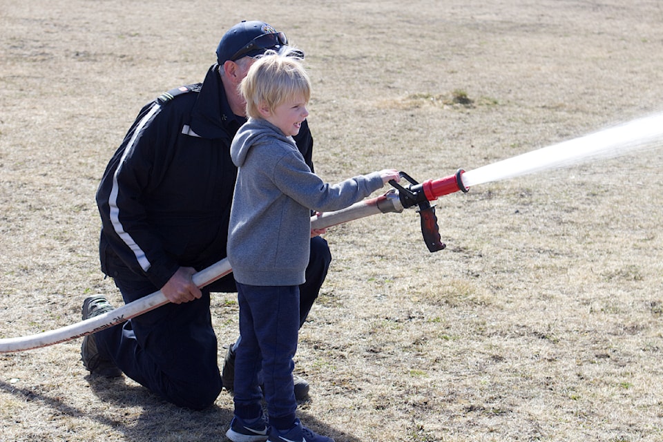 Kaleb Goddard tries out the fire hose during the Interlakes Volunteer Fire Department open house held at the Interlakes Community Centre on Apr. 19 (Misha Mustaqeem photo - 100 Mile Free Press) 