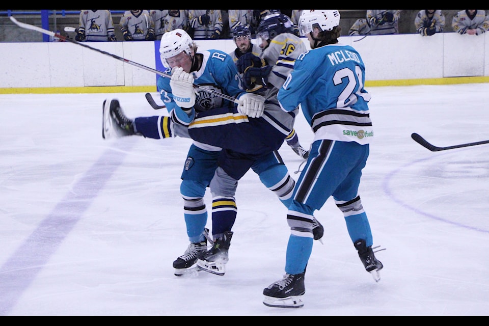 100 Mile House Wrangler Luke McFarlane gets sandwiched between a pair of Revelstoke Grizzlies. (Patrick Davies photo - simplymastery)