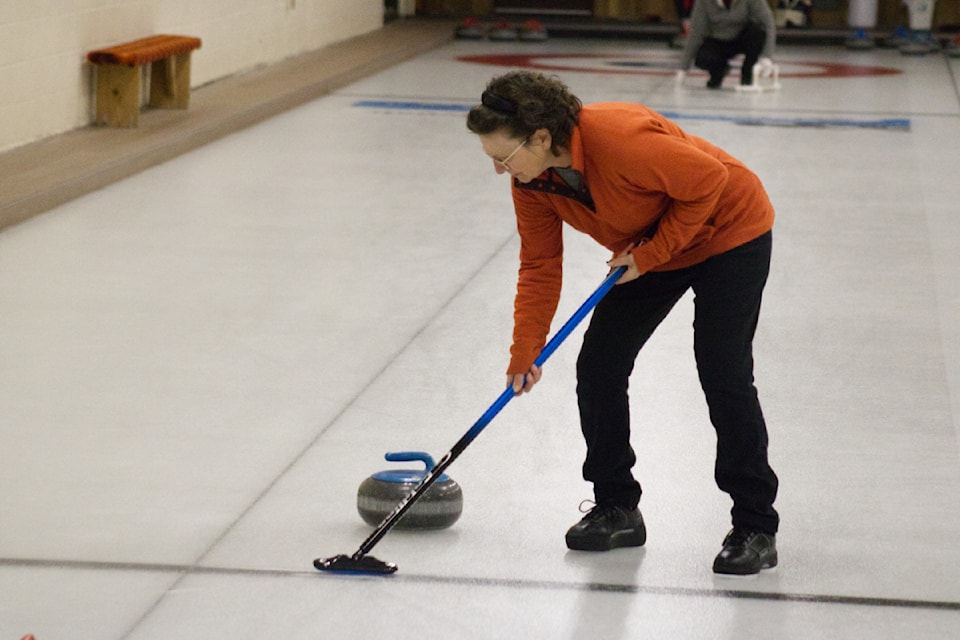 Maria Hamilton sweeps during the Open Doubles Bonspiel held at the 100 Mile House Curling Club on Feb. 8 (Misha Mustaqeem photo - 100 Mile Free Press)