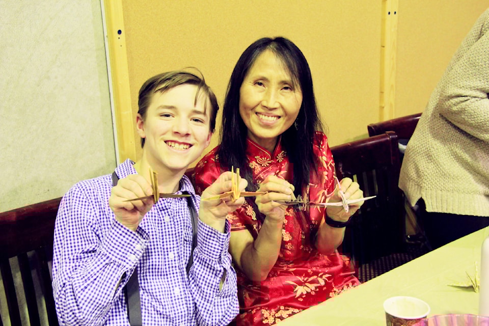Thayus de Groot and Sang-Hee Robinson show off some of the paper cranes folded by them and other members of the community during Chinese New Year Celebrations on Saturday, Feb. 1. These paper cranes will be used in Cecilia de Groot's planned 1,000 paper crane mobile being auctioned off in support of Logan Sikiric, a local South Cariboo resident currently fighting cancer. de Groot said she also raised $175 for Sikiric from community donations.  (Cecilia de Groot photo)
