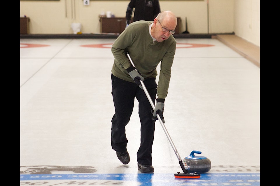 Richard O'Brien participates in a curling match during the Men's Bonspiel held at the 100 Mile Curling Club on Jan. 11. (Misha Mustaqeem photo - 100 Mile Free Press) 