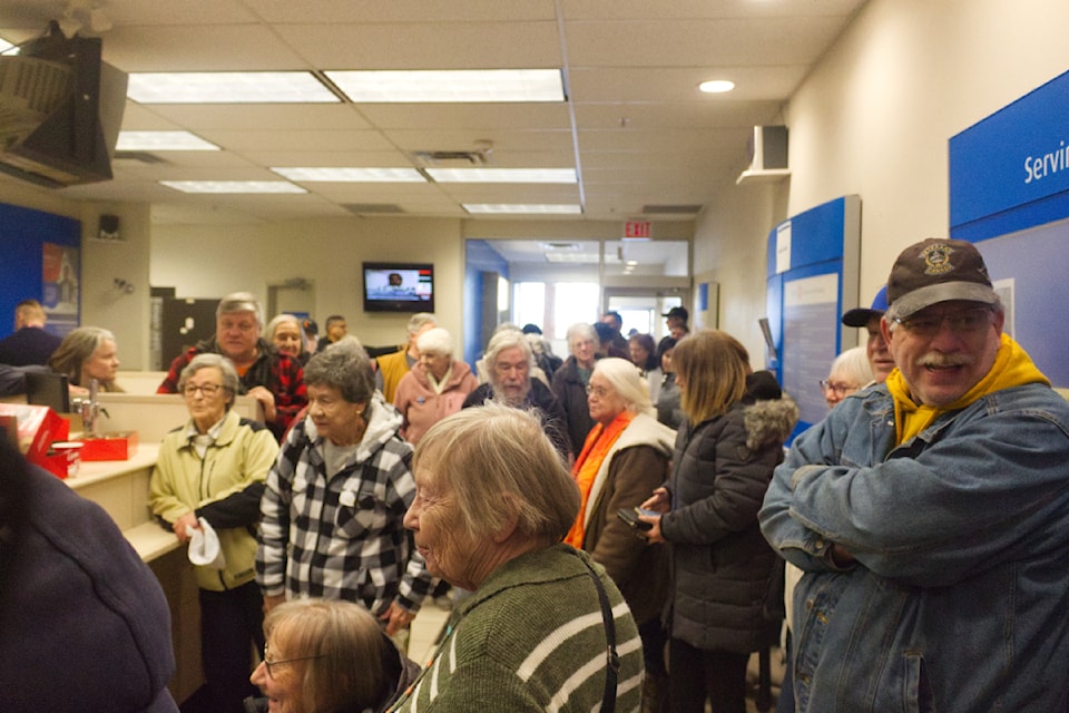 A crowd of about 50 people gather at the 100 Mile BMO branch in the Cariboo Mall on Jan. 22 to express their feelings over the branch being shut down. (Misha Mustaqeem photo - 100 Mile Free Press)
