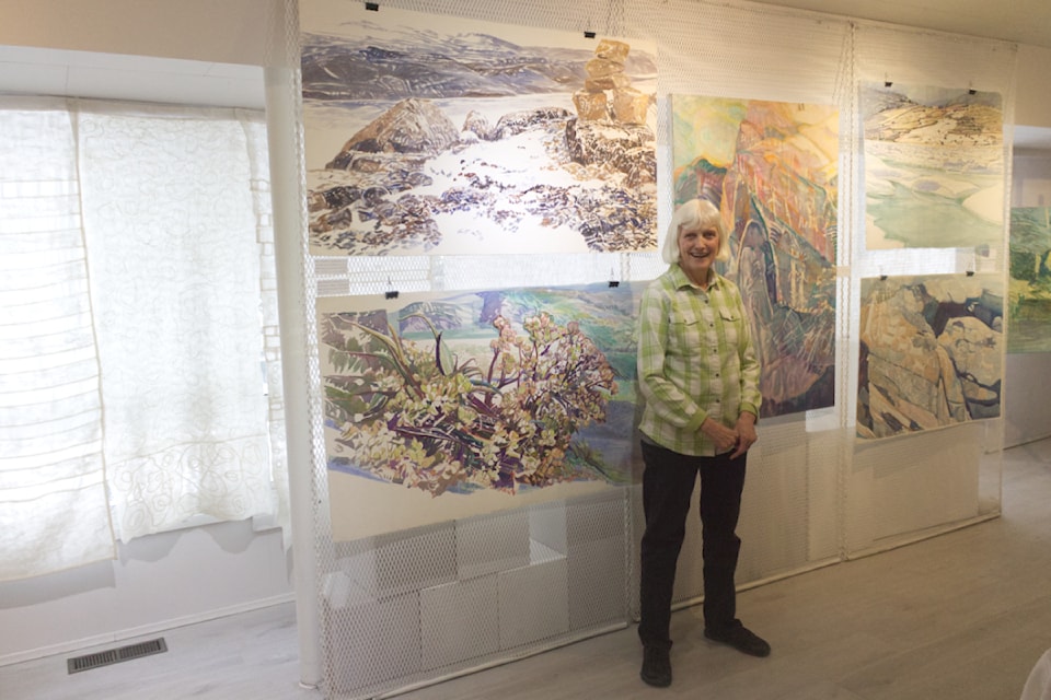 Collette French, the curator of Audrey Garwood's paintings, stands next to two of her paintings at the Parkside Art Gallery on Jan. 11 at One Artist's World, Paintings by Audrey Garwood. The show is set to run until Feb. 9 (Misha Mustaqeem photo - simplymastery)