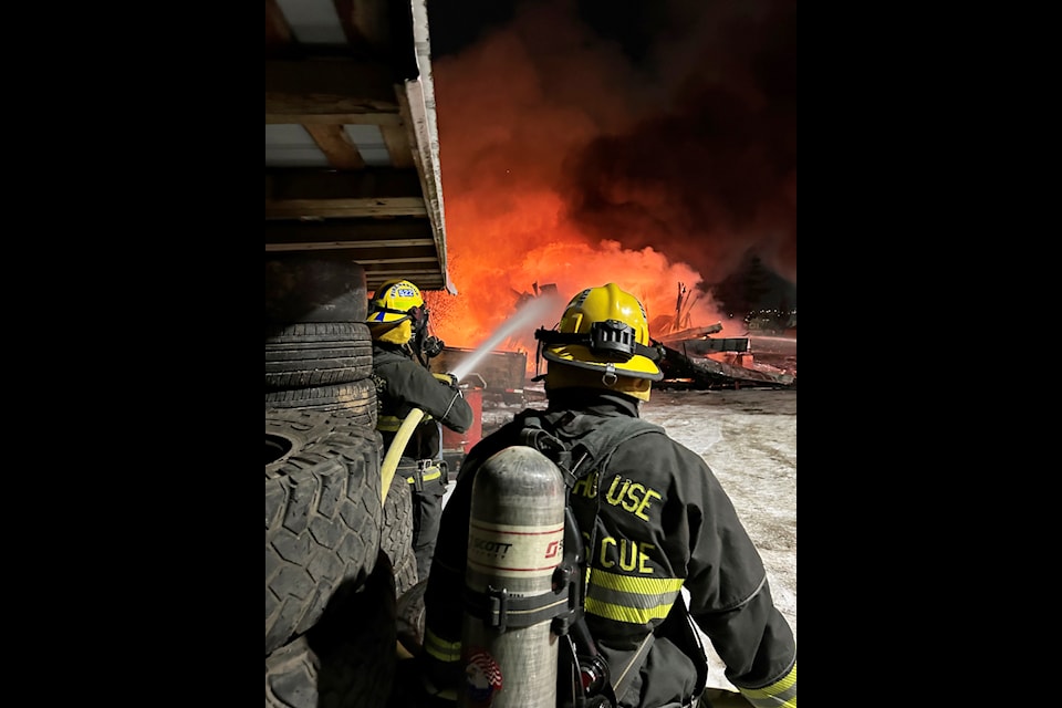 Members of 100 Mile Fire Rescue work to extinguish a shop fire that broke out on Alpine Avenue on Monday, Jan. 13, 2025. (Dave Bissat photo)