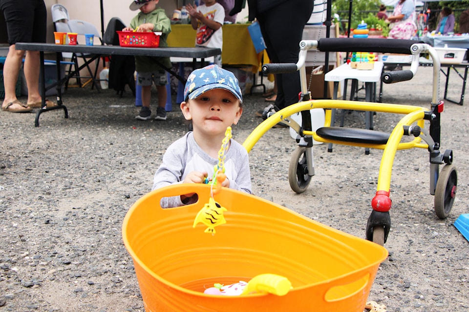 Nash Byrne goes fishing at the Cariboo Chilcotin Partners of Literacy's booth at the South Cariboo Farmers' Market on Friday, July 25. (Patrick Davies photo - 100 Mile Free Press)