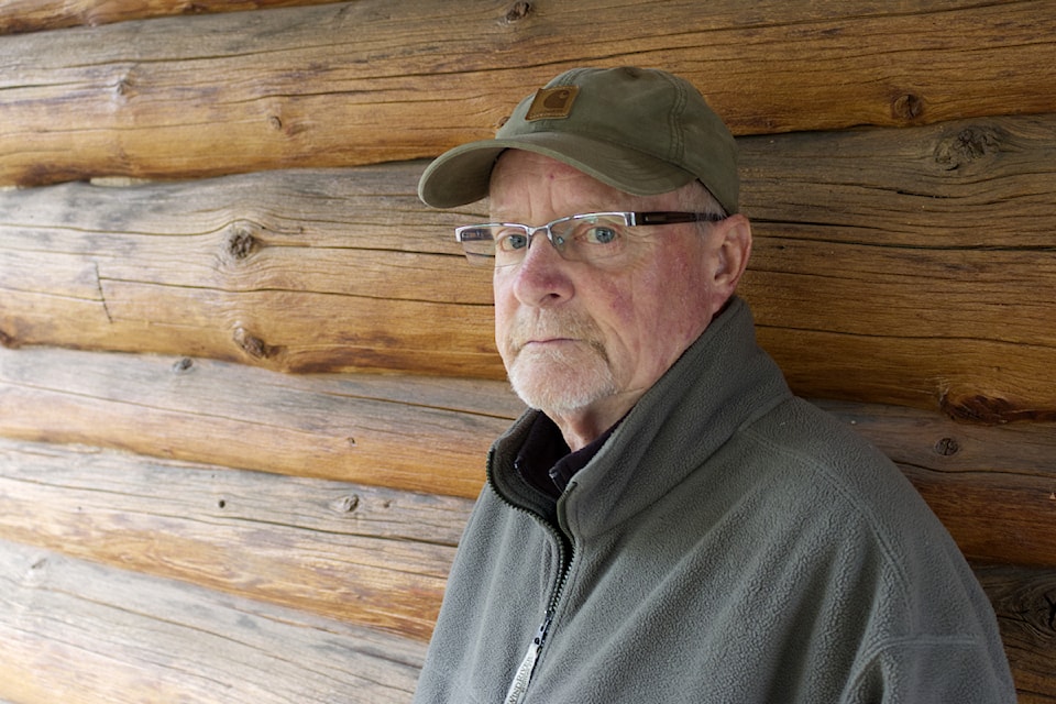 Rick Kyllo stands next to the deteriorated logs at the 99 Mile clubhouse. (Misha Mustaqeem photo - simplymastery)