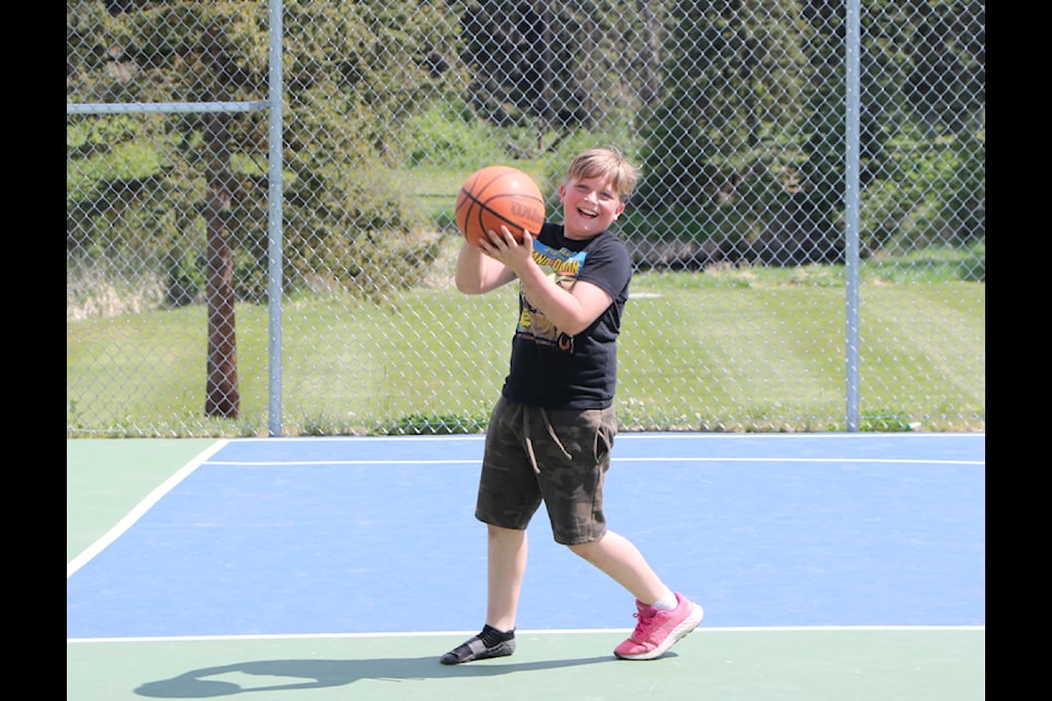 Caleb Slootweg laughs as he tries to score a basket in Centennial Park on Friday, June 6. (Patrick Davies photo - simplymastery)