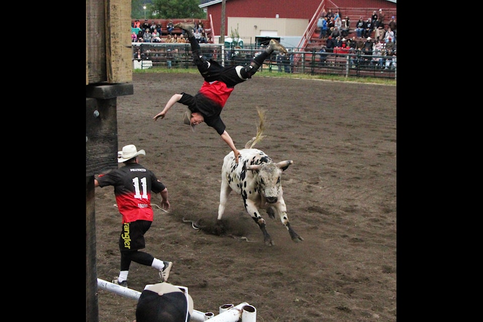 Bull fighter Cordell Pinchbeck is flipped through the air during the end of the fourth annual Logan Parent Bulls and Barrels on Friday, June 13, in 100 Mile House. Pinhchbeck luckily landed on his feet and was uninjured. (Patrick Davies photo - simplymastery)