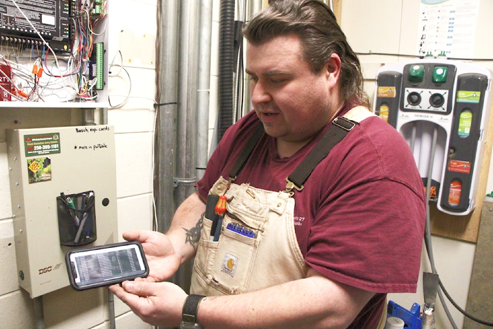 School District 27 electrical lead Adam Van Riesen shows the 100 Mile Free Press how he can monitor and disarm Peter Skene Ogden Secondary School's new security system from his cell phone. (Patrick Davies photo - 100 Mile Free Press)
