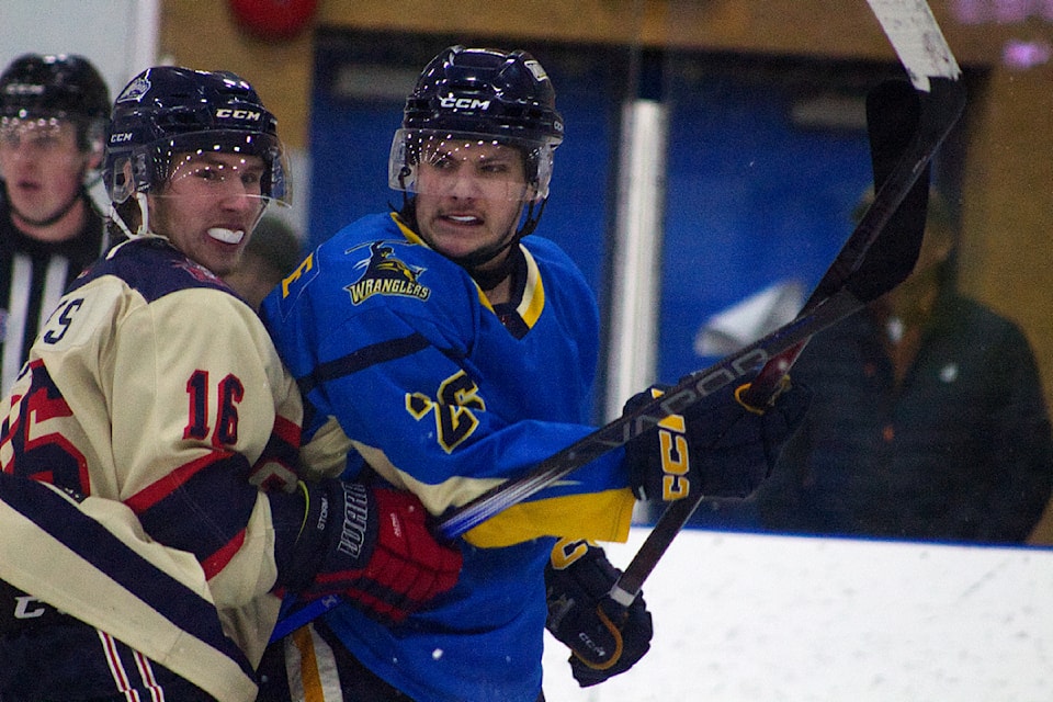 Wranglers player Luke McFarlane scowls at Kamloops Storm player Logan Bates during the Wranglers vs. Storm game at the South Cariboo Rec Centre on March 16. (Misha Mustaqeem photo - 100 Mile Free Press)