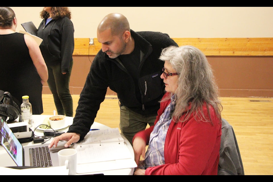 Farhan Umedaly helps Demian Pettman troubleshoot an issue during the Telus STORYHIVE Empowered Filmmaker program in 100 Mile House. (Patrick Davies photo - simplymastery)