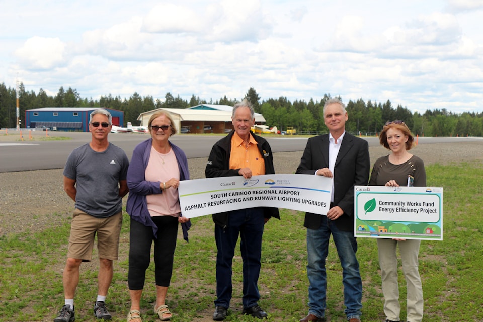 From left to right, Larry Davis, Margo Wagner, Al Richmond, Eric de Vries and Maureen Pinkney holding up banners by provincial and federal governments