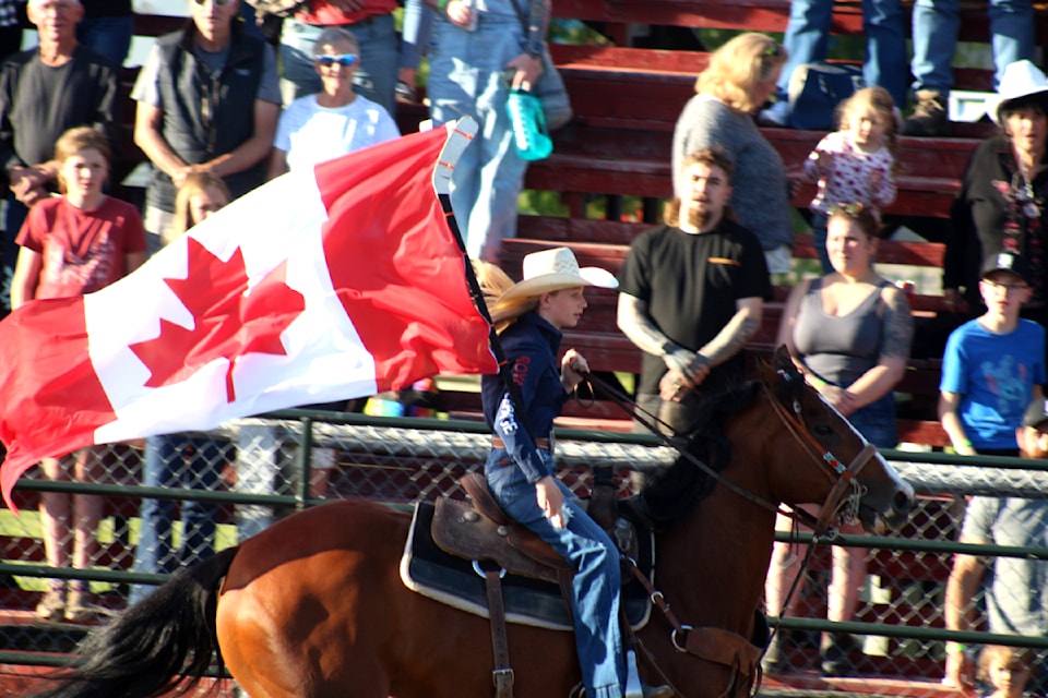 Paisley McNolty, with her horse galloping around the 100 Mile Outriders field during the Canadian national anthem at the Logan Parent Bull Riding event