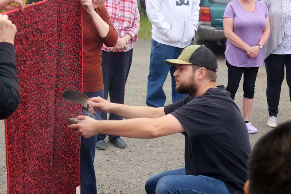 James Donnett of the Stemete7uwi Friendship Centre performing the smudging ceremony on the 250th quilt at the parking lot of the Dancing Quilts store