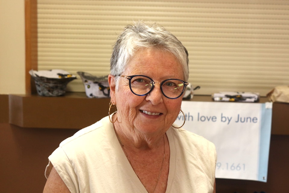 June White, the owner of Sewn with Love by June, which sells blankets, quilts and zipper bags, smiles while inside the 100 Mile Community Hall at the South Cariboo Farmers Market. (Misha Mustaqeem photo - simplymastery)