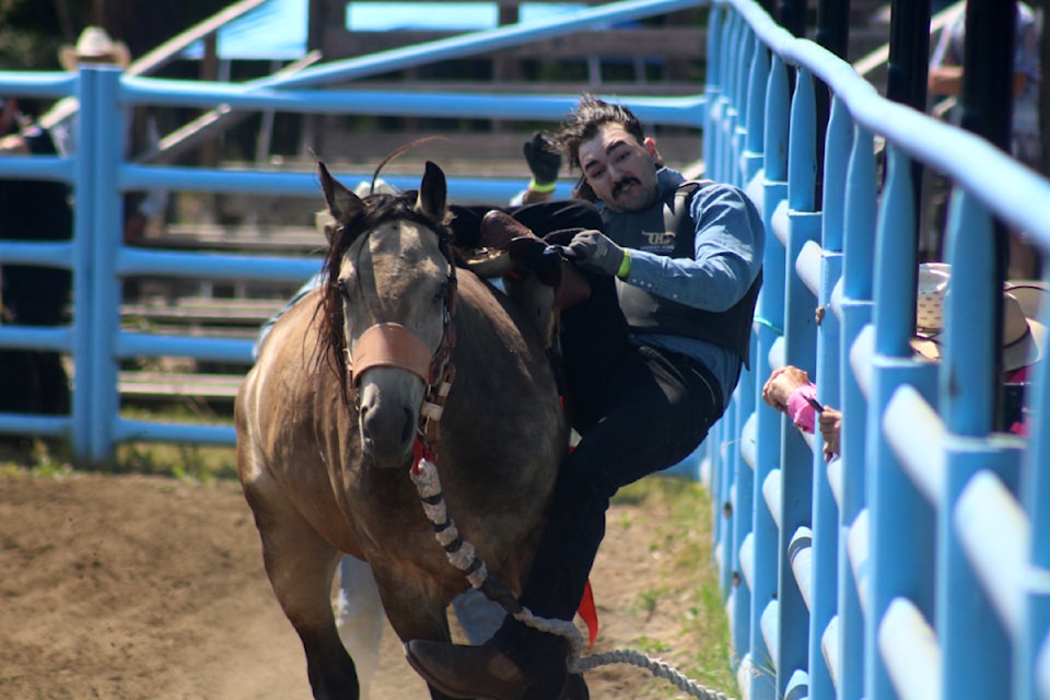 Riley Richardson of Calgary holds onto a horse during the Canadian Wild Horse Race at the Interlakes Rodeo at the Interlakes Rodeo Grounds on Saturday, August 4. 