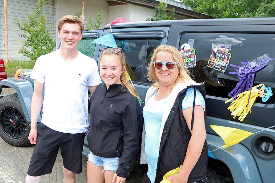 Cameron Ardiel (from left) and Maddy Martin 2019 PSO grads help Heather Wood decorate their car prior to taking part in the reverse Grad Parade. (Patrick Davies photo - 100 Mile Free Press)