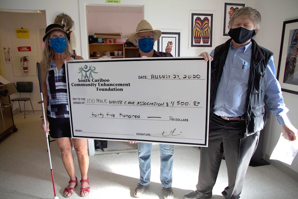 Lori Fry, left, and Jim Vinson, president of the 100 Mile District Blind and Visually Impaired White Cane Club, receive a $4,500 grant from Doug Dent, president of the South Cariboo Community Enhancement Society. (Kelly Sinoski photo, 100 Mile Free Press)