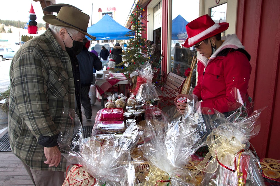 Denis Fluet, left, checks out the baked goods at Ruth Park’s stall at Clinton’s first outdoor Christmas market at Hunnies Mercantile on Dec. 13. (Kelly Sinoski photo - 100 Mile Free Press).
