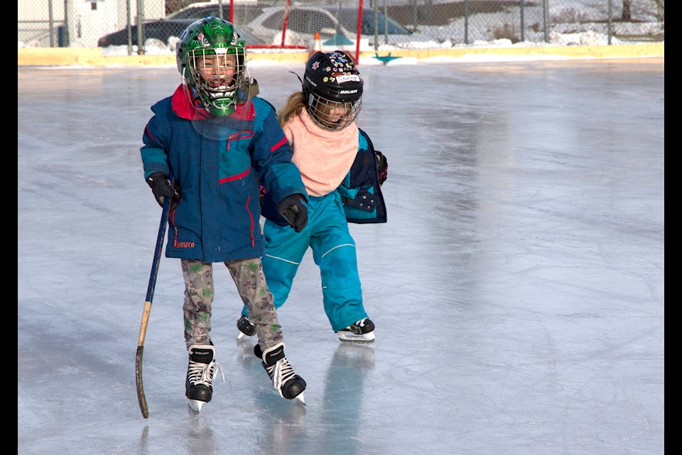 Jethro Rolland, 8, and Guinevere Rolland, 6, test out the ice at the new outdoor rink in 100 Mile House. (Kelly Sinoski photo - 100 Mile Free Press).
