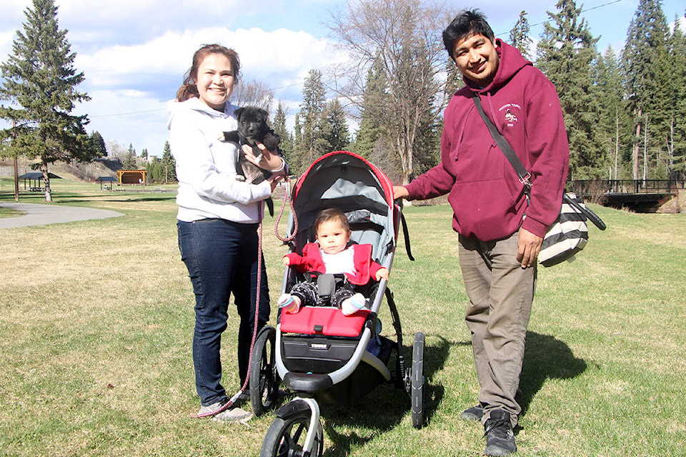 Katrina Pukacz (from left) holds her dog Daisy while out for a walk with her daughter Celina Alphonse and partner Alexis Alphonse. (Patrick Davies photo - 100 Mile Free Press)