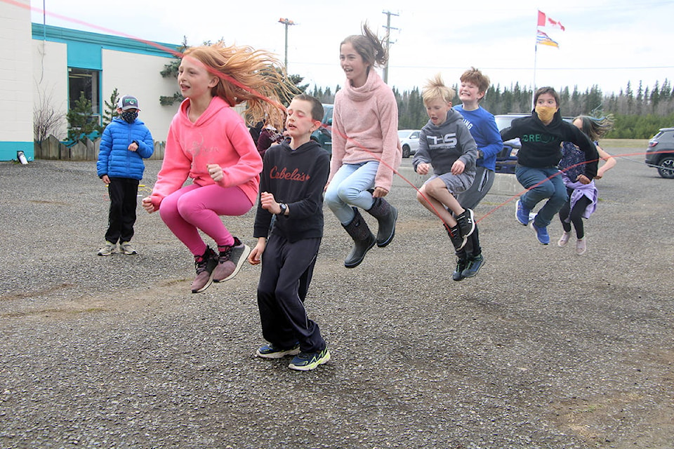 Horse Lake Elementary students laugh as they try to jump together over a skipping rope at their school’s Jump Rope for Heart event last week. (Patrick Davies photo - 100 Mile Free Press)