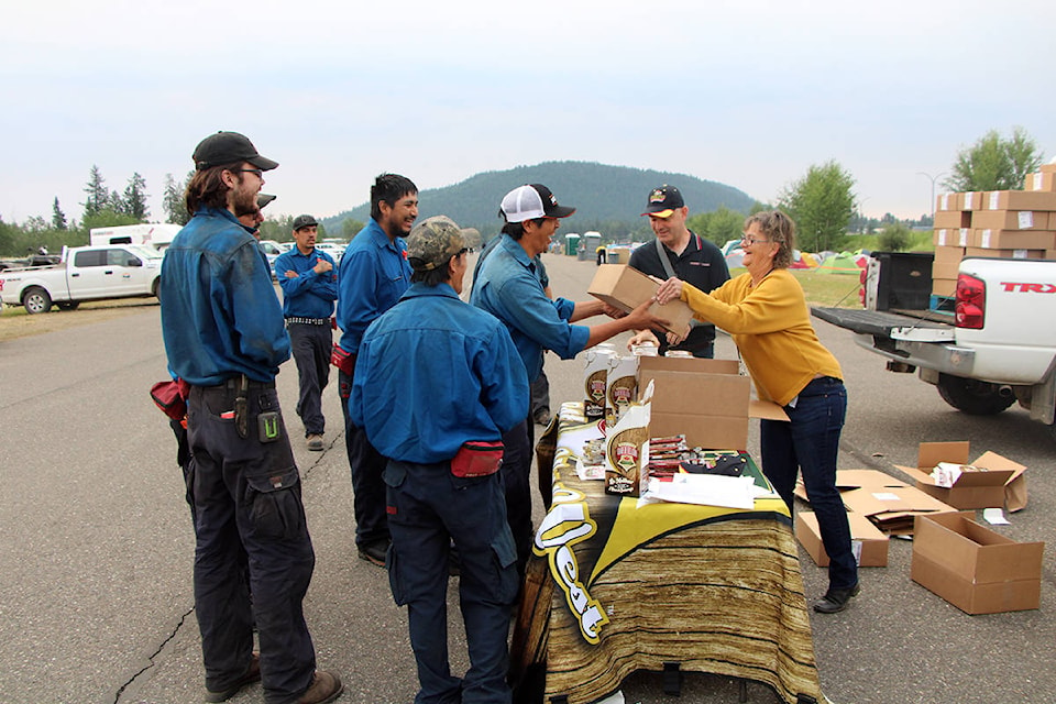 Members of the Canim Lake Fire Brigade receive some pepperoni from Country Prime Meats’ Markus Springmann and Ulli Vogler. (Patrick Davies photo - 100 Mile Free Press)