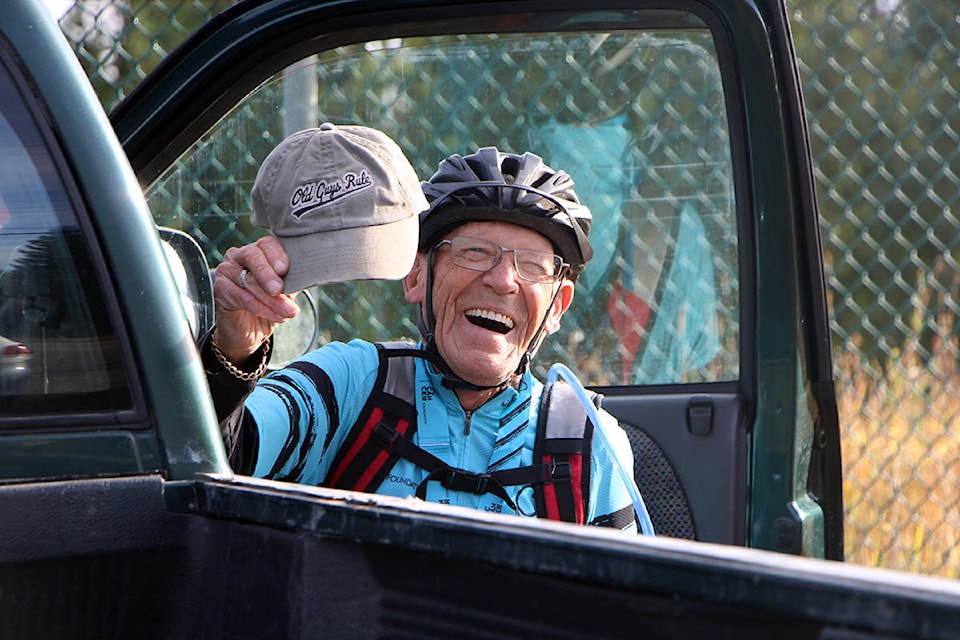Harry Bishop laughs as he holds up a hat reading ‘Old Guys Rock’ while he prepares to head out on a Tour De Cure ride from Lone Butte to South Green Lake and back. (Patrick Davies photo - 100 Mile Free Press)