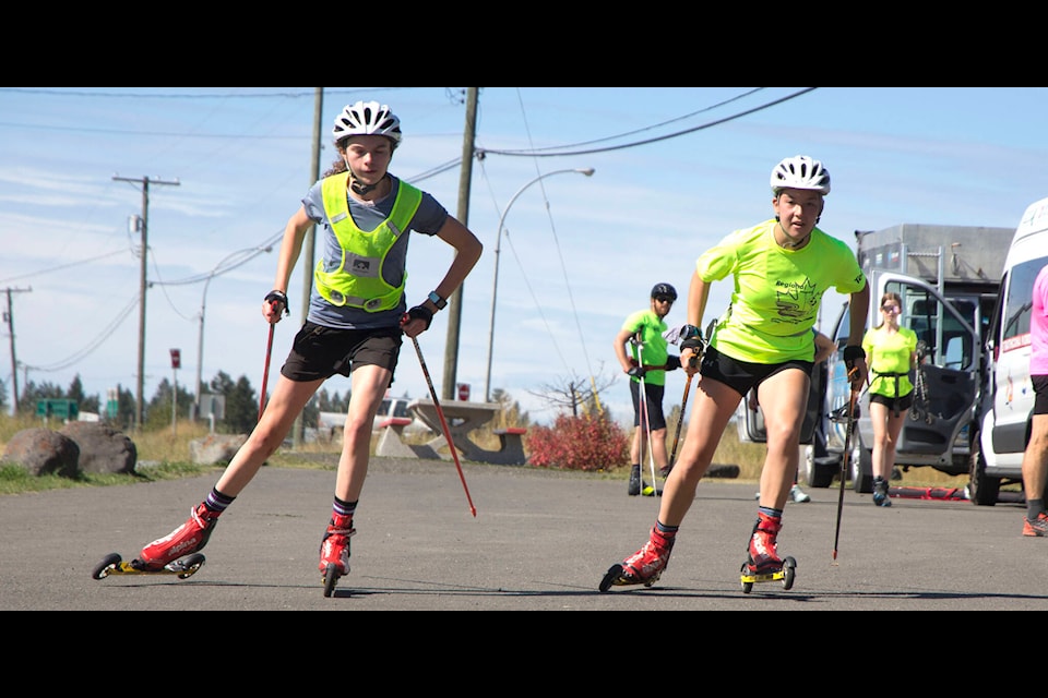 Telemark skiers Chloe Shivers, 14 and Aya Sentesy, 15, take a practice run in the parking lot across from the 108 Heritage site. The two girls are part of Cross Country B.C.’s talent squad. (Kelly Sinoski photo - 100 Mile Free Press).