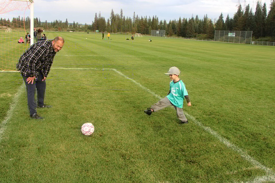 100 Mile House Soccer Association coach Jeff Martens smiles as player Malikai Frank takes a shot against him on net. (Patrick Davies photo - simplymastery)