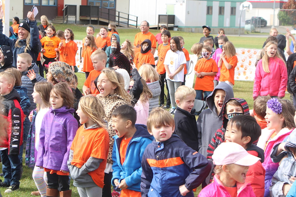 Students and teachers of 100 Mile Elementary School respond to Mike Retasket’s call during their Orange Shirt Day Celebration. (Patrick Davies photo - 100 Mile Free Press)