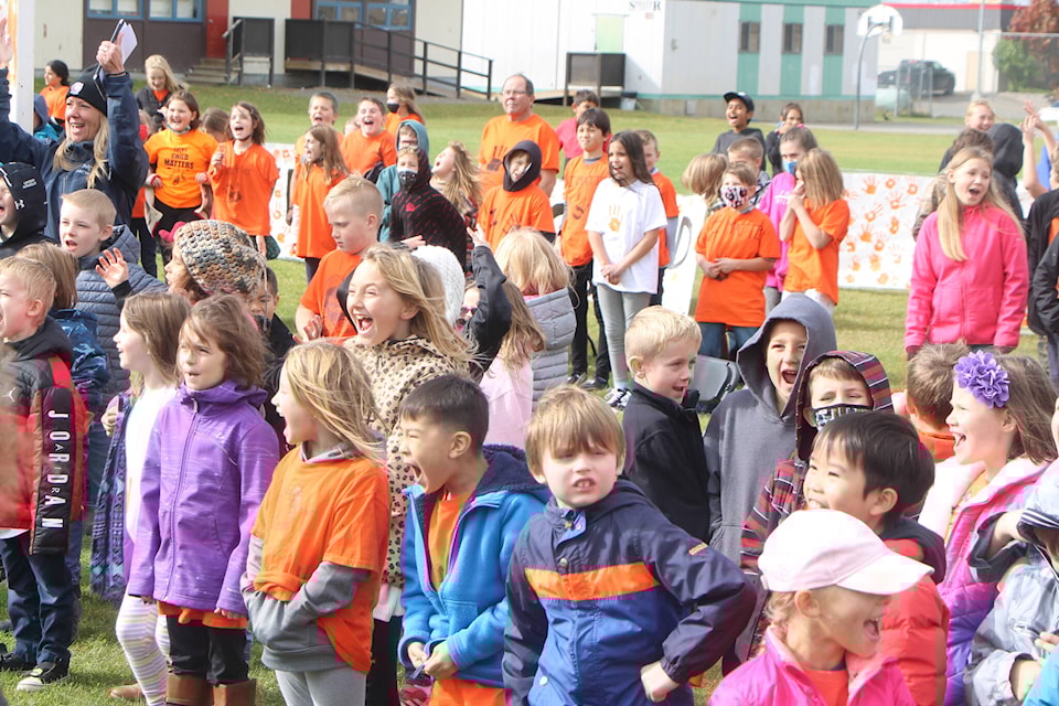 Students and teachers of 100 Mile Elementary School respond to Mike Retasket’s call during their Orange Shirt Day Celebration. (Patrick Davies photo - simplymastery)