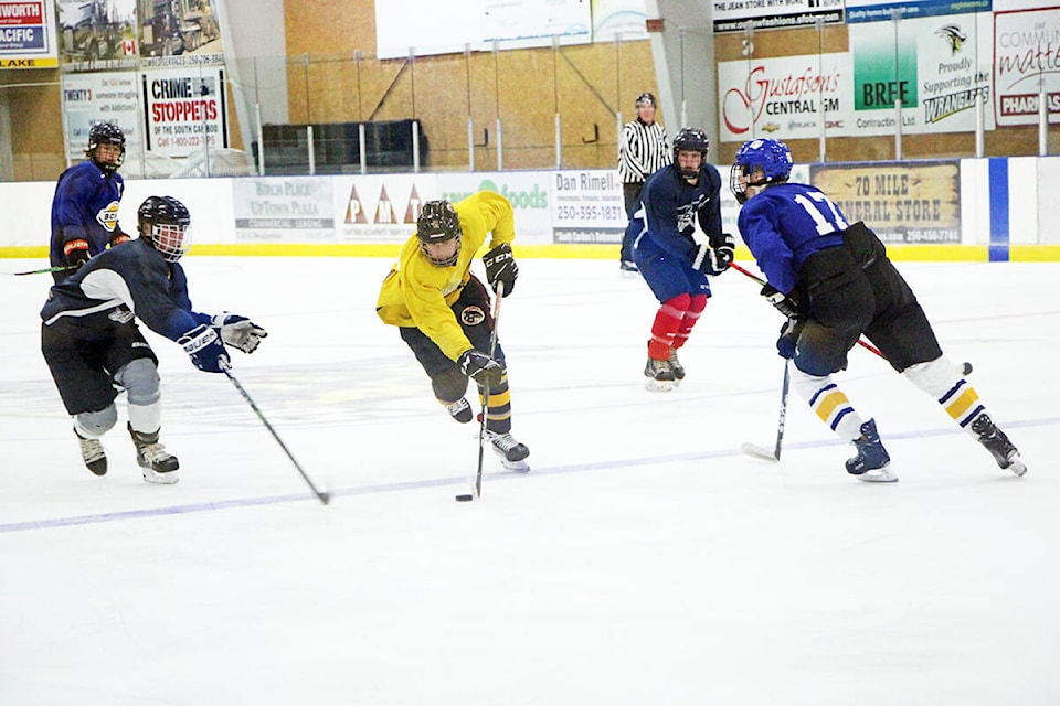 A 100 Mile Wrangler hopeful skates between two opponents during the Wranglers’ training camp earlier this month. (Patrick Davies photo - simplymastery)