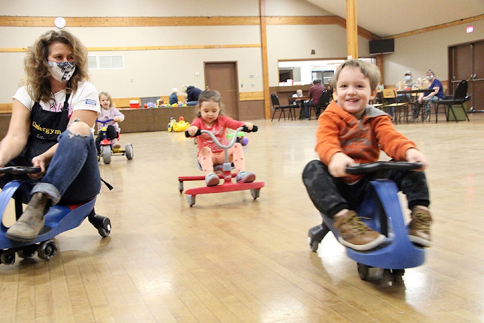 Elke Baechmann (left) goes for a ride on scooters with Kallie Hall, Rylee Langford and Oden Hall. (Patrick Davies photo - 100 Mile Free Press)