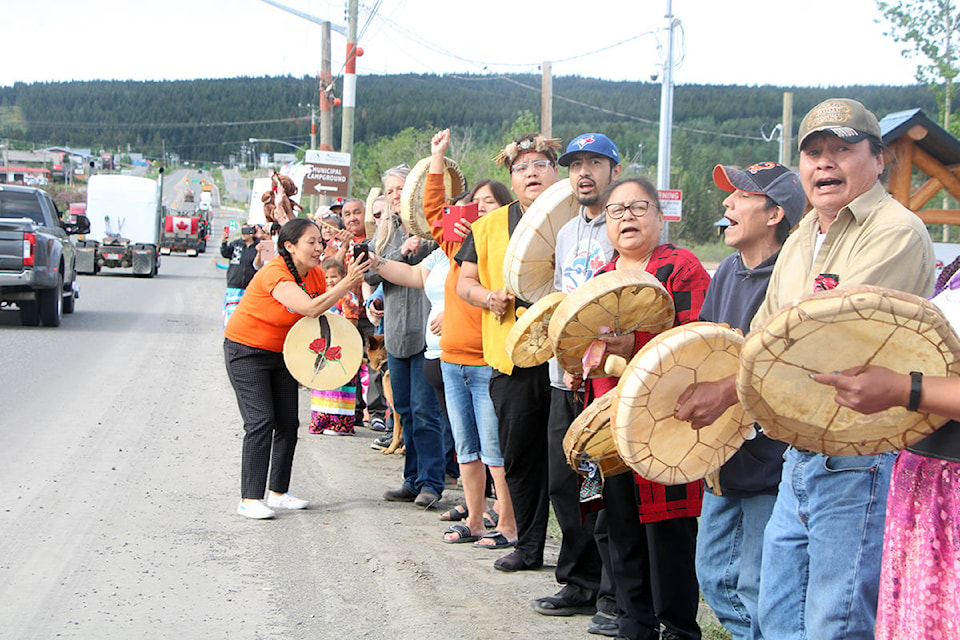 Members of the Canim Lake Band and 100 Mile House community welcome a convoy of trucks passing through town on the way to the Kamloops Residental School. (Patrick Davies photo - 100 Mile Free Press)