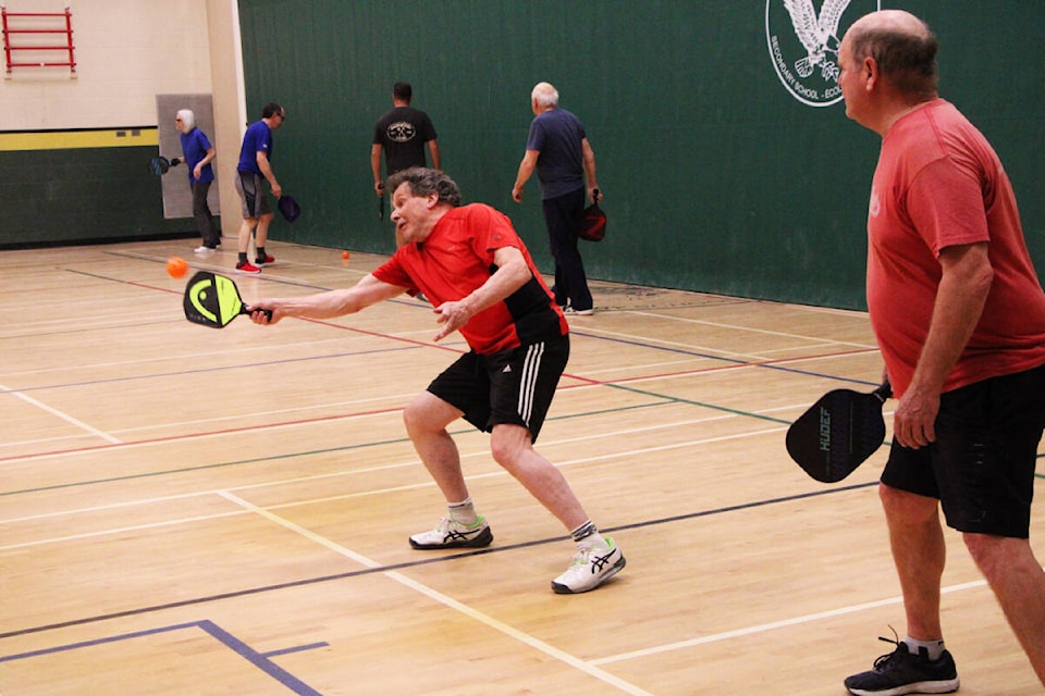 Greg Crompton watches as Don Kinasewich successfully intercepts a pickleball with his paddle. (Patrick Davies photo - simplymastery)