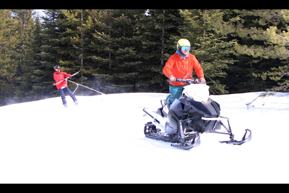 Olen Grady rides on a pair of skies behind Ryan Grady as they take part in Mount Timothy’s Braap and Board relay race. (Patrick Davies photo - simplymastery)