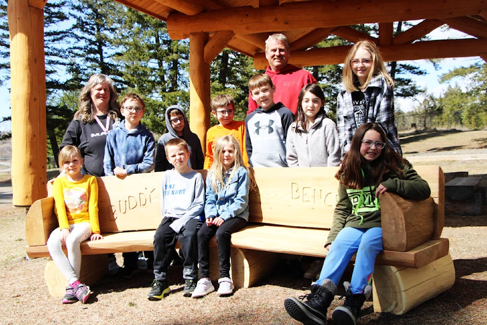Students and teachers of Lac La Hache Elementary School are happy to have a new Buddy Bench in the school playground, donated by Peter Arnold (in red, at back). (Patrick Davies photo - 100 Mile Free Press)