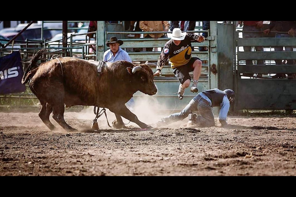 Cody Call jumps in front of a bull to protect his friend Logan Parent after he was bucked while bull riding. (Lauren Carruthers photo)