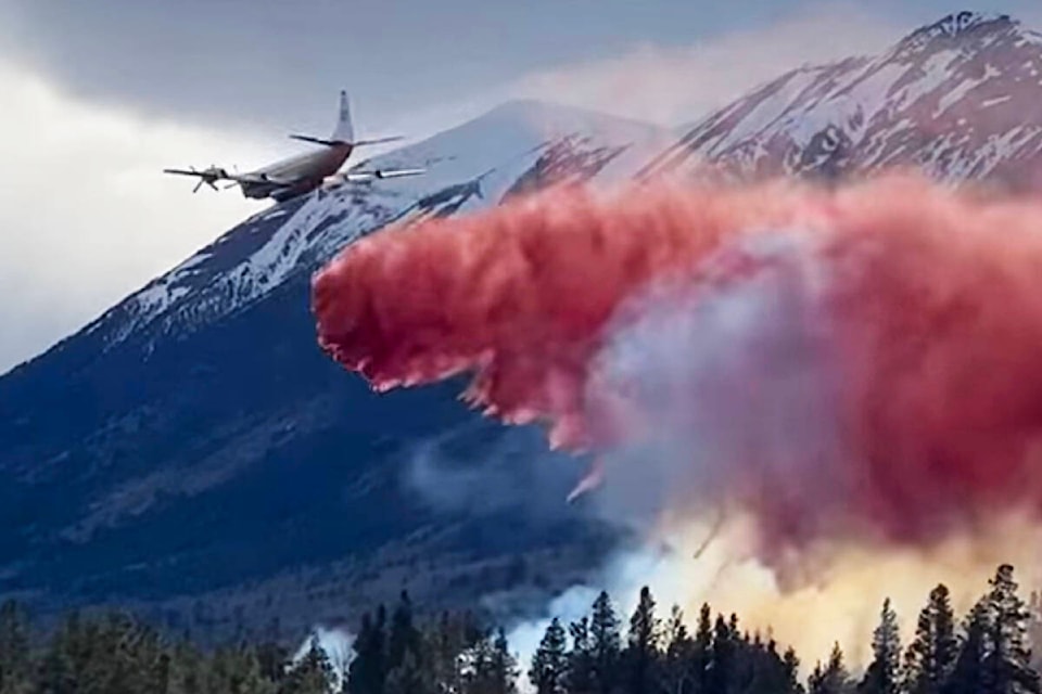 An air tanker and crew works to contain a wildfire in the Nemiah Valley despite strong winds. (Chief Jimmy Lulua photo)