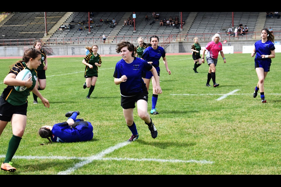 PSO Eagles captain Emily Machado (left) runs with the ball during a game against RE Mountain Secondary School at rugby provincials last week. (Darren Emery photo)